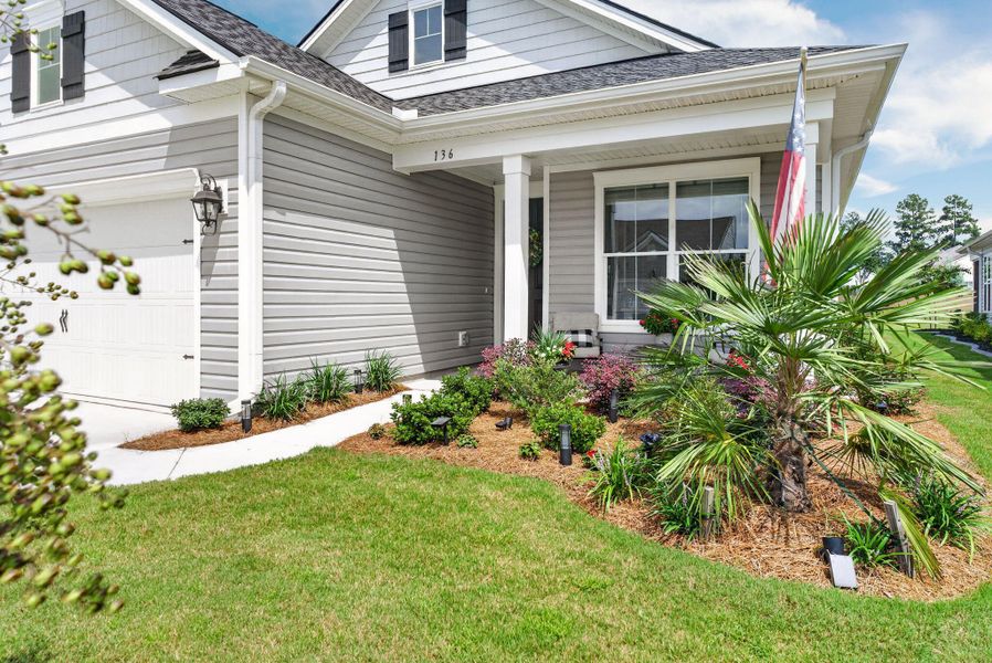 Exterior details and patio area of a home in K. Hovnanian's® Four Seasons at Lakes of Cane Bay, Summerville (Image 22).