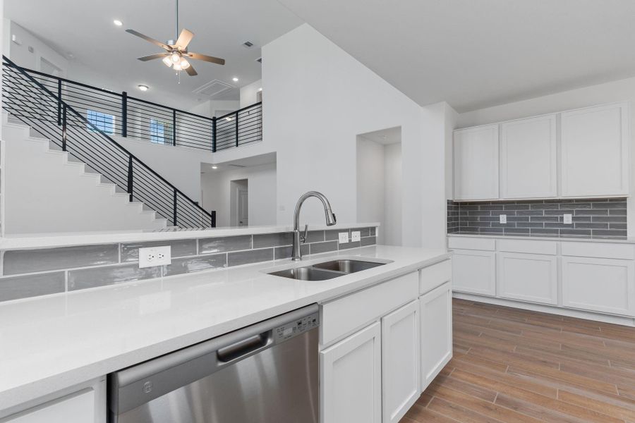 Enjoy a deep undermount stainless-steel sink with a stylish swan neck pull-out faucet—perfect for prepping meals or cleaning up with ease. Sleek quartz countertops and a modern tile backsplash tie it all together in this beautifully appointed kitchen. Enjoy a deep undermount stainless-steel sink with a stylish swan neck pull-out faucet—perfect for prepping meals or cleaning up with ease. Sleek quartz countertops and a modern tile backsplash tie it all together in this beautifully appointed kitchen.