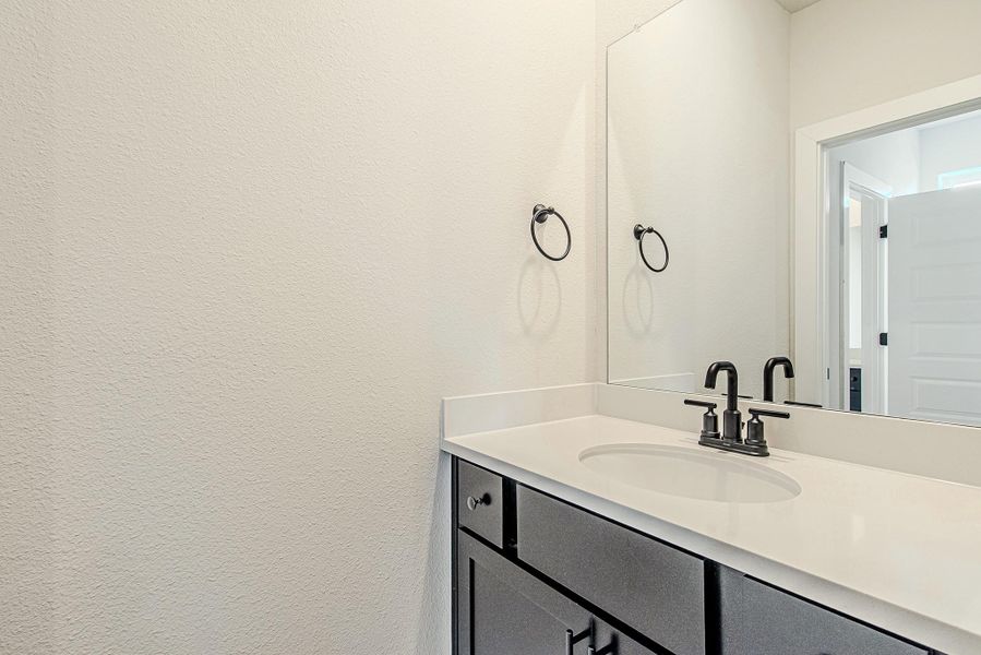 Half bath with modern vanity and simple, clean finishes.