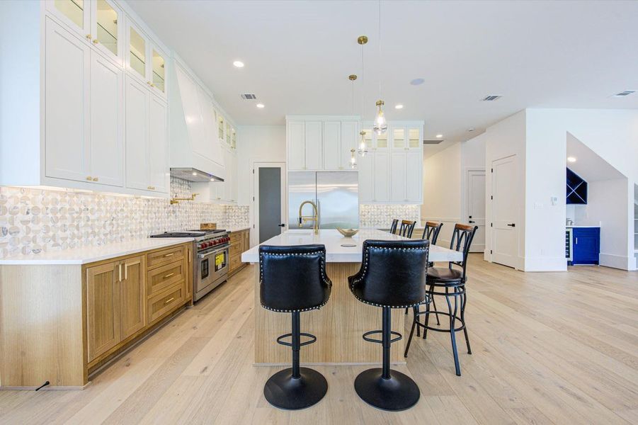 Wolf range with double ovens and a stylish kitchen faucet that glows blue, green, or red to indicate water temperature.