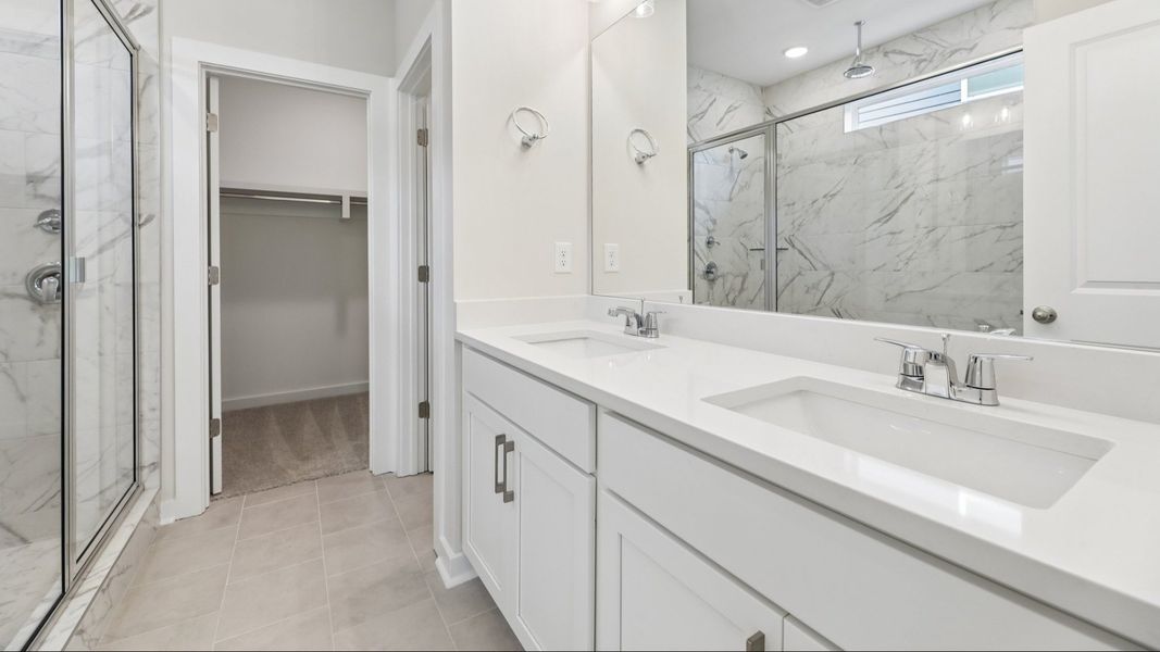 Primary bathroom with dual vanity and access to closet