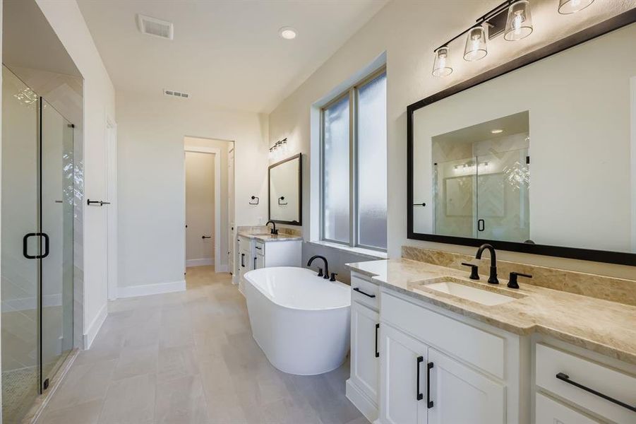 Bathroom featuring two vanities, a freestanding bath, a stall shower, and recessed lighting Bathroom featuring two vanities, a freestanding bath, a stall shower, and recessed lighting