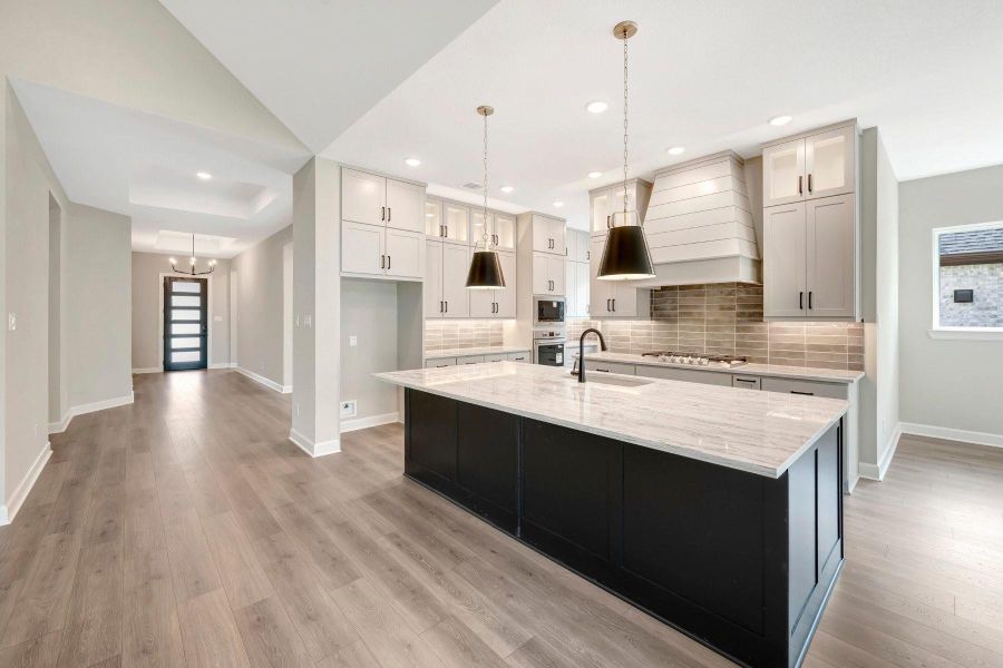 A view of the Family room with corner stone fireplace wall, as well as view to the Entry!