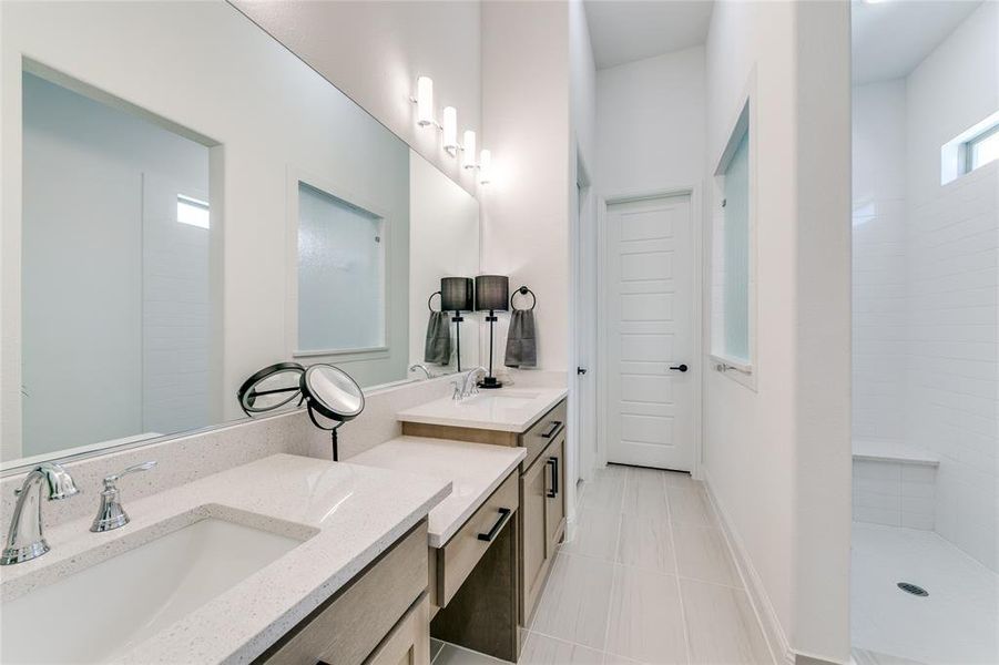 Bathroom featuring tile flooring, vanity, and walk in shower