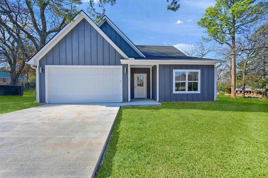 View of front of house with a garage and a front yard