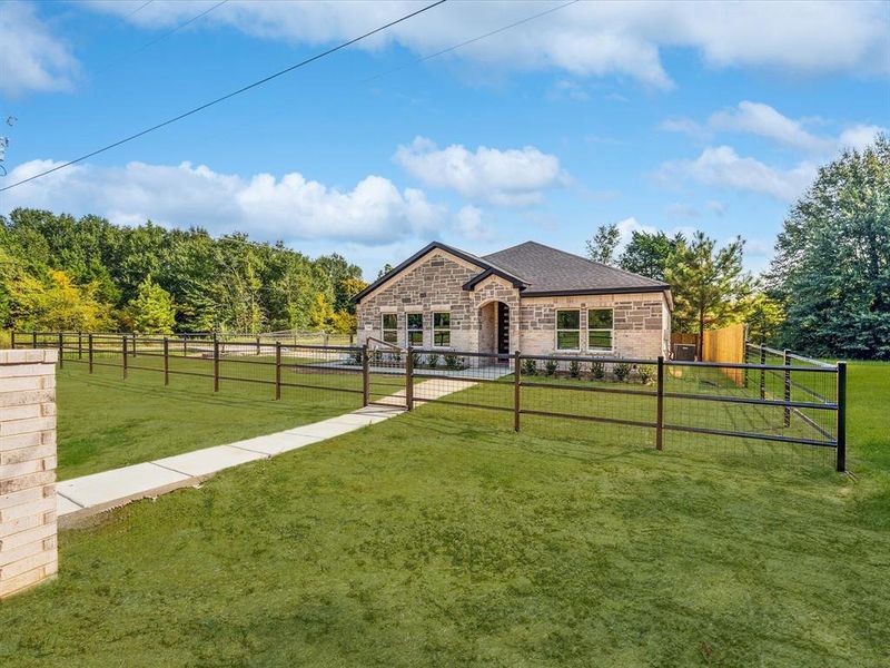 French country style house with stone siding, brick siding, and a view of rural / pastoral area