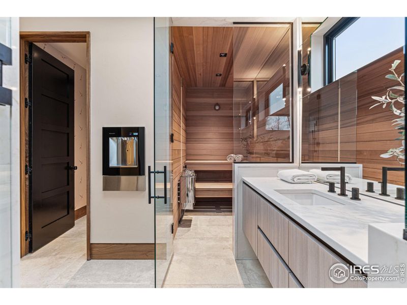 Changing room, sauna and steam shower complete this space. Elkay Built-In Filtered Water Dispenser. Eclipse by Shiloh Cabinetry, Pental Quartz Tramonto Polished Slab & Franz Viegener Faucets.