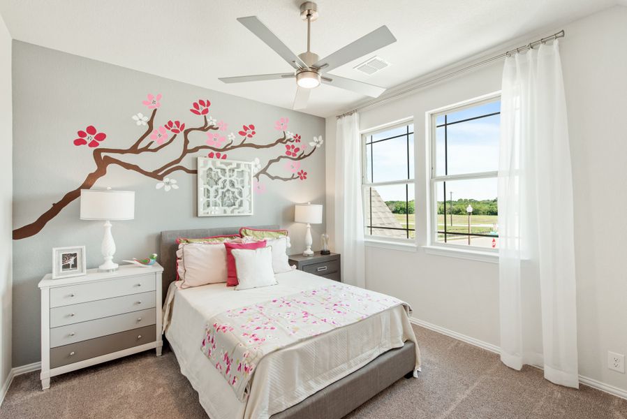 Bedroom with cherry blossom wall mural, ceiling fan, white dresser, and double windows with sheer curtains
