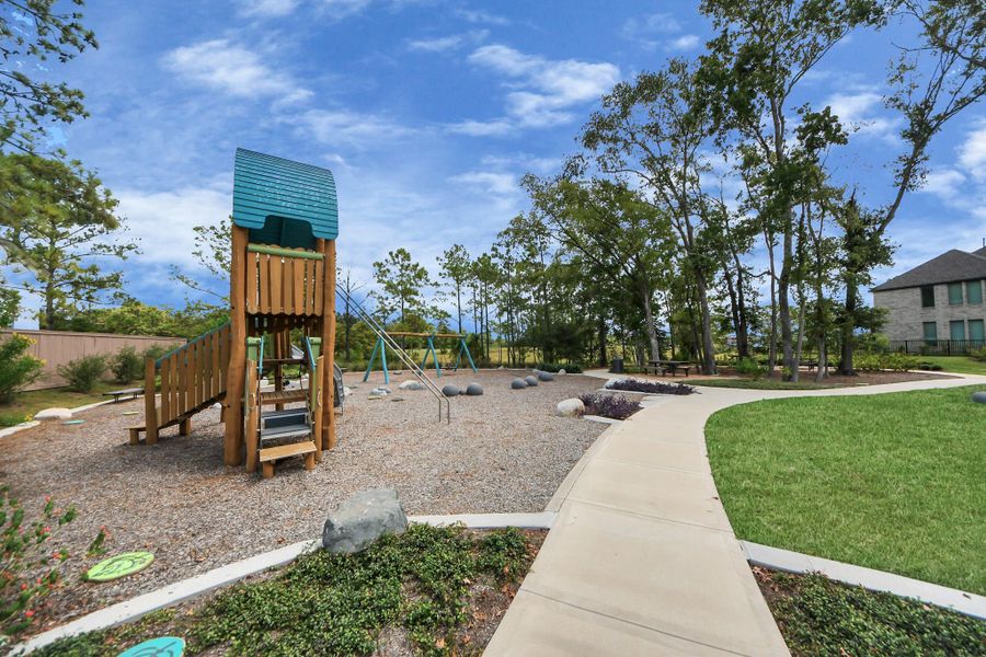 Neighborhood pocket park with playground & swings, picnic tables, and winding trails beneath mature trees—just a short stroll from home.