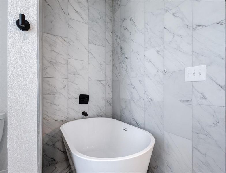 Bathroom with tile walls and a bathtub