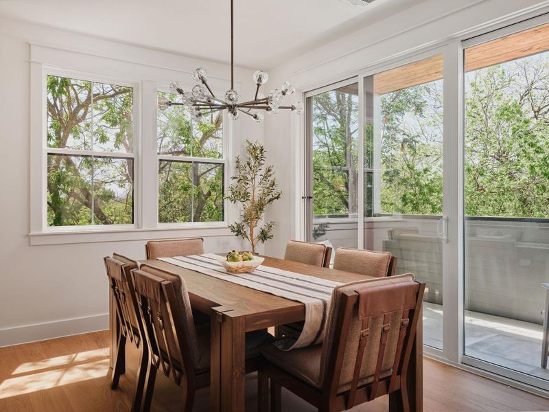 Dining space with hanging lights and light wood-style floors
