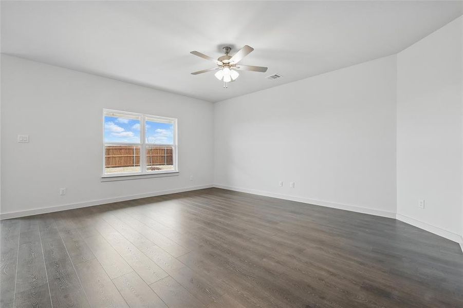 Spare room with dark wood-style flooring and a ceiling fan Spare room with dark wood-style flooring and a ceiling fan