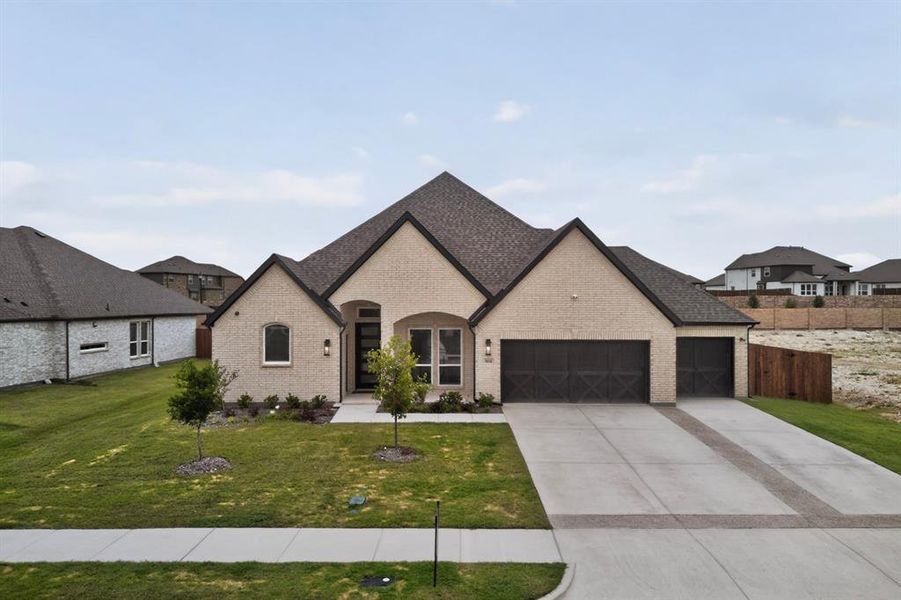 Contemporary single-story residence featuring a light brick facade and a dark shingle roof Contemporary single-story residence featuring a light brick facade and a dark shingle roof