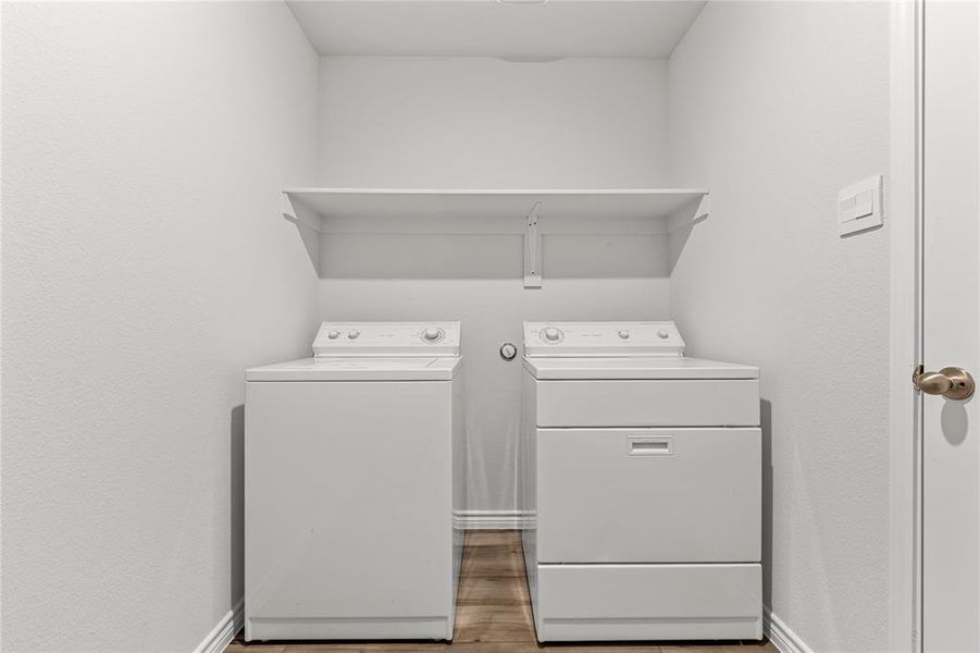 Laundry area featuring wood finished floors and washer and dryer