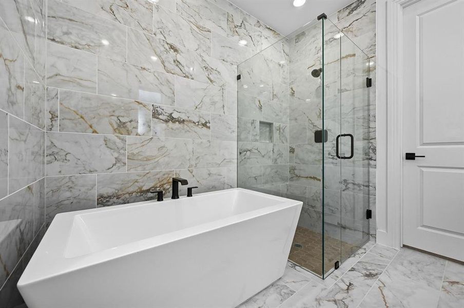 Full bathroom featuring marble finish flooring, tile walls, a freestanding tub, and a marble finish shower Full bathroom featuring marble finish flooring, tile walls, a freestanding tub, and a marble finish shower