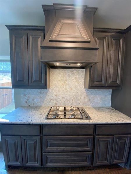 Kitchen features a custom cabinet vent hood