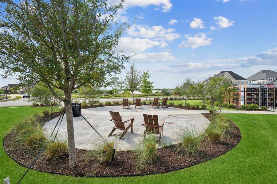 Community stone patio area with surrounding landscaping and mature trees