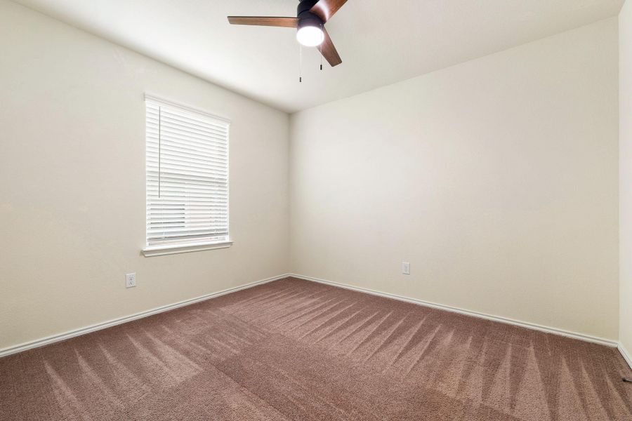A well-proportioned bedroom with ample natural light and a comforting ceiling fan for year-round comfort. A well-proportioned bedroom with ample natural light and a comforting ceiling fan for year-round comfort.