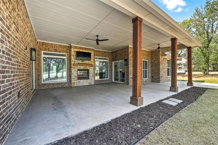 View of patio featuring ceiling fan and a glass covered fireplace View of patio featuring ceiling fan and a glass covered fireplace