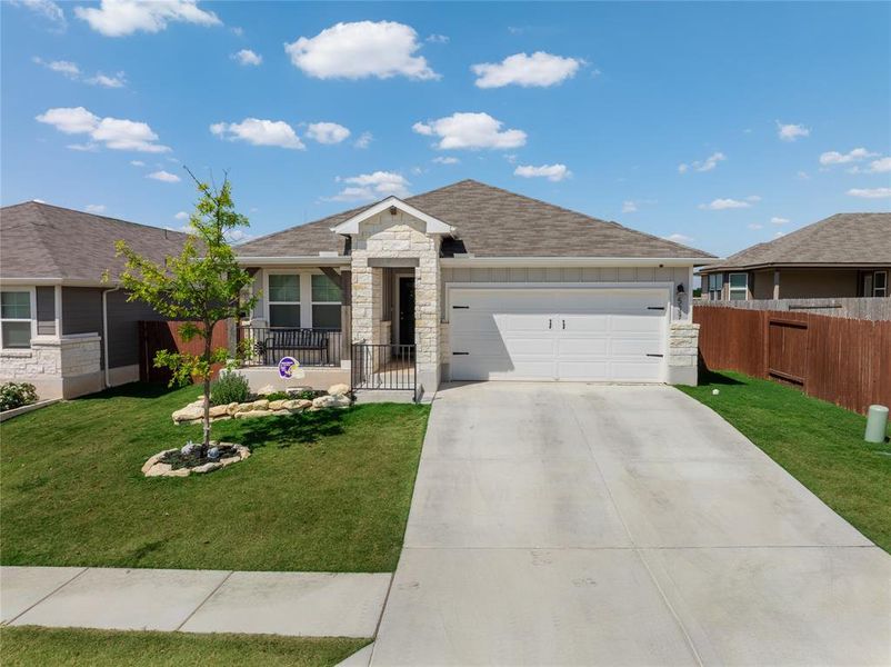 Single story home featuring stone siding, concrete driveway, an attached garage, a shingled roof, and board and batten siding