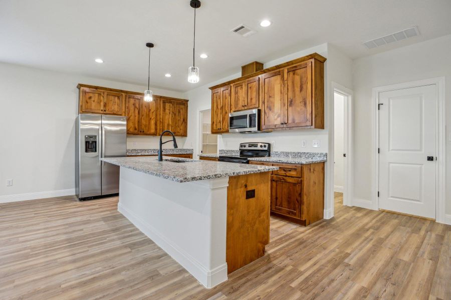Kitchen featuring visible vents, a sink, brown cabinets, and appliances with stainless steel finishes