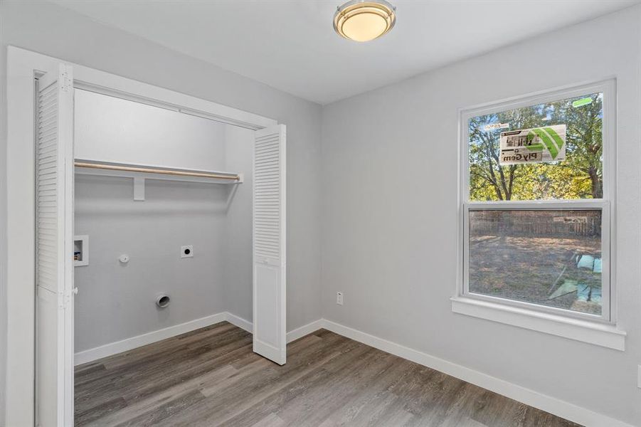 Washroom with gas dryer hookup, hookup for an electric dryer, and wood-type flooring