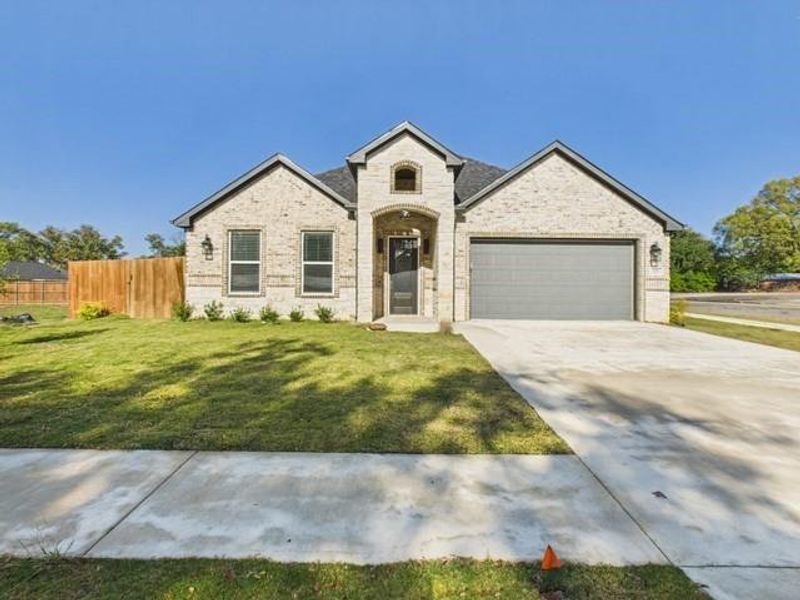 View of front of home with concrete driveway, brick siding, and an attached garage View of front of home with concrete driveway, brick siding, and an attached garage