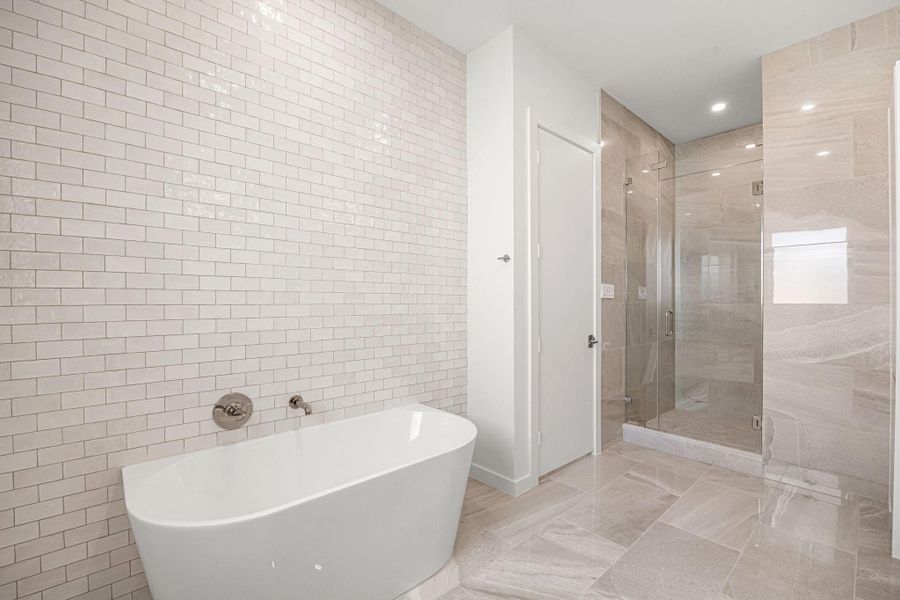 Secondary bath also offers a soak tub & walk-in shower w/ a vast wall of zellige tile & dual vanities.