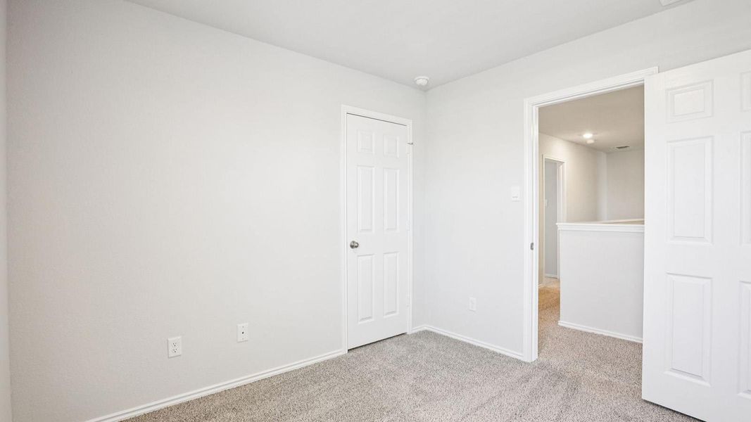 Room featuring light gray wall paint, gray carpet flooring, white trim, and white paneled doors