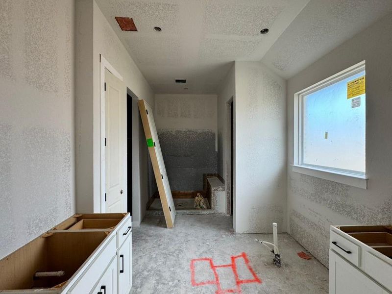 Bathroom featuring a textured ceiling and a textured wall