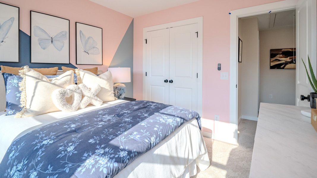 Secondary bedroom with carpet and windows