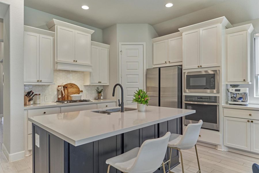 Hexagon marble-like backsplash and upgraded spray faucet with disposal air-switch.