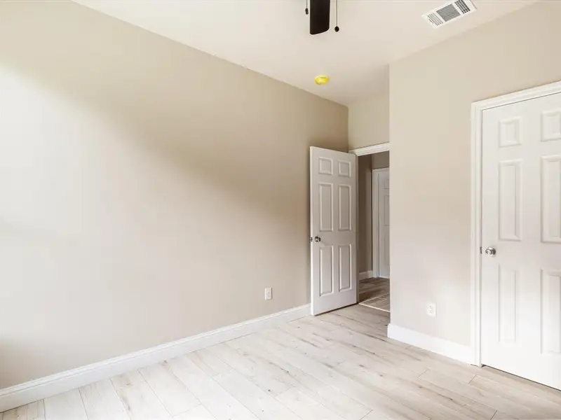 Unfurnished bedroom featuring light wood-type flooring and ceiling fan Unfurnished bedroom featuring light wood-type flooring and ceiling fan