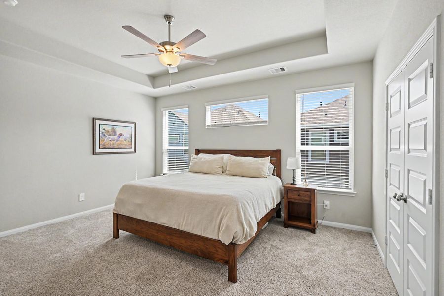 The second-floor primary bedroom features high ceilings and large windows that create a bright, open feel. The second-floor primary bedroom features high ceilings and large windows that create a bright, open feel.