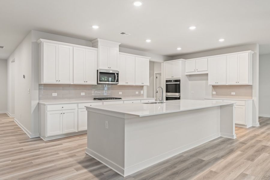 A kitchen with white cabinets.