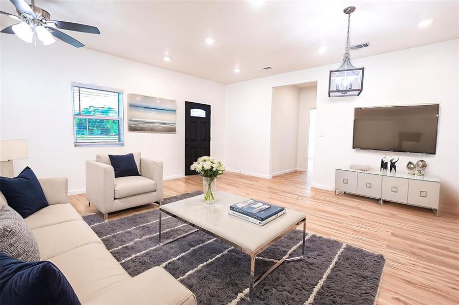 Living area with wood finished floors, ceiling fan, and recessed lighting