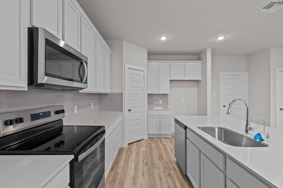 A kitchen with white cabinets.