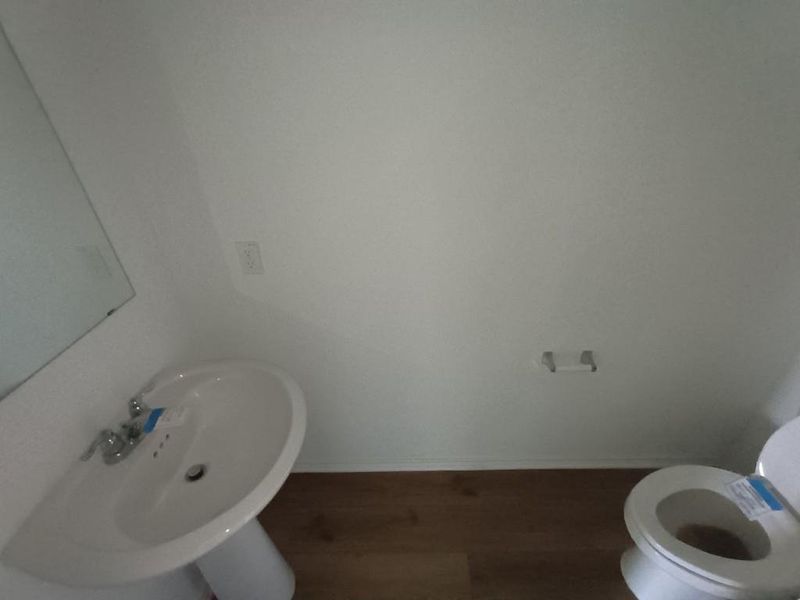 Bathroom featuring baseboards and dark wood-type flooring Bathroom featuring baseboards and dark wood-type flooring