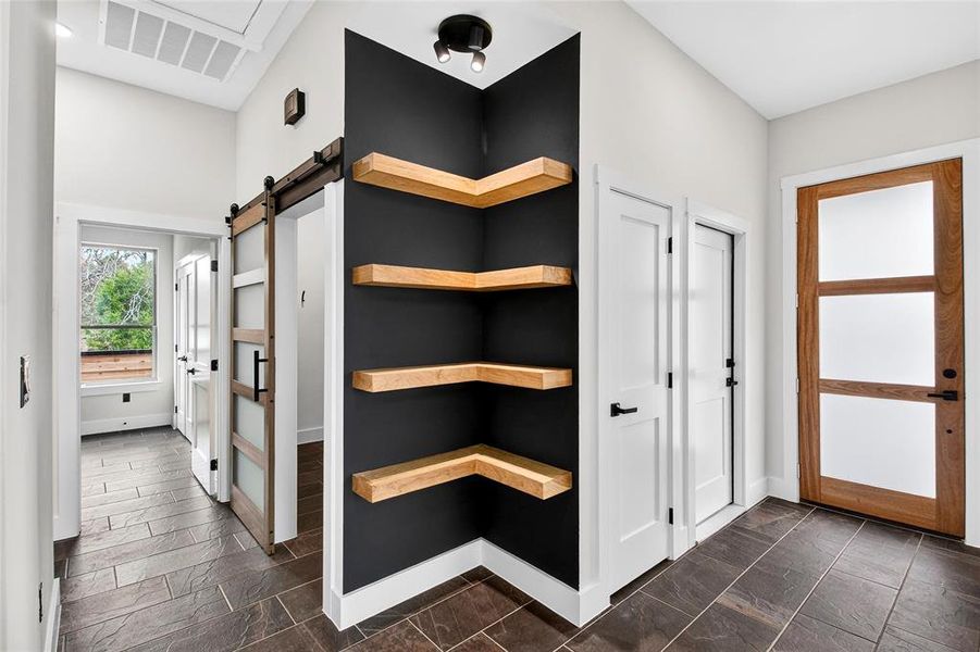 Mudroom featuring stone tile flooring and a barn door