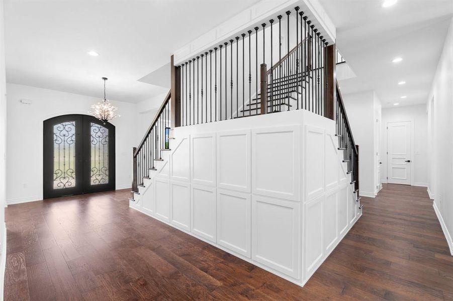 Entrance foyer featuring stairway, a chandelier, french doors, dark wood-type flooring, and recessed lighting Entrance foyer featuring stairway, a chandelier, french doors, dark wood-type flooring, and recessed lighting