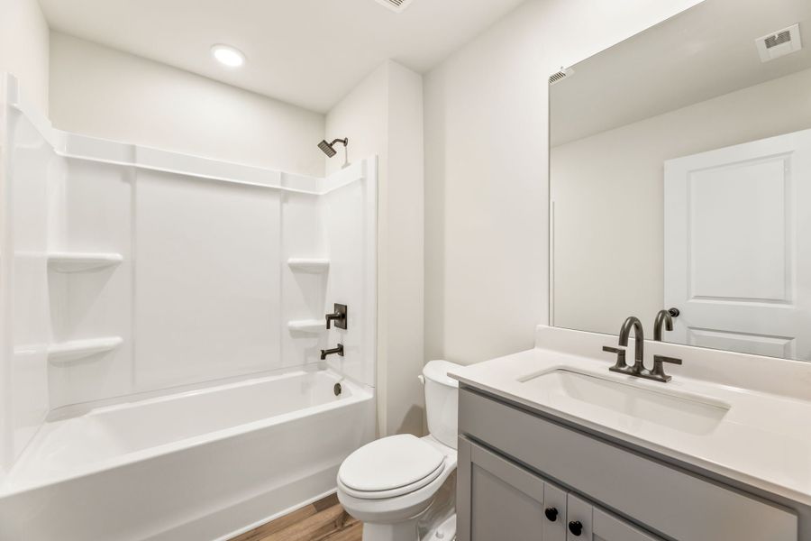 A bathroom with a tub sink and toilet. A bathroom with a tub sink and toilet.