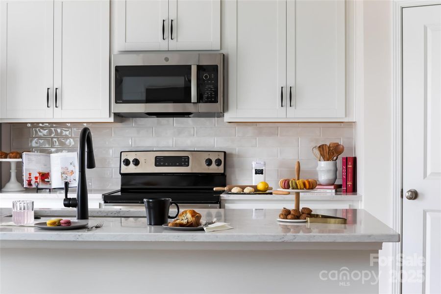 Designer Backsplash and Crisp White Cabinetry. *Model Photos | Actual Finishes, Structural Selections, and Orientation May Vary.