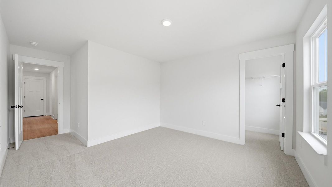 Inviting bedroom with tasteful finishes and large windows that create a fresh, open ambiance located in Moore, SC