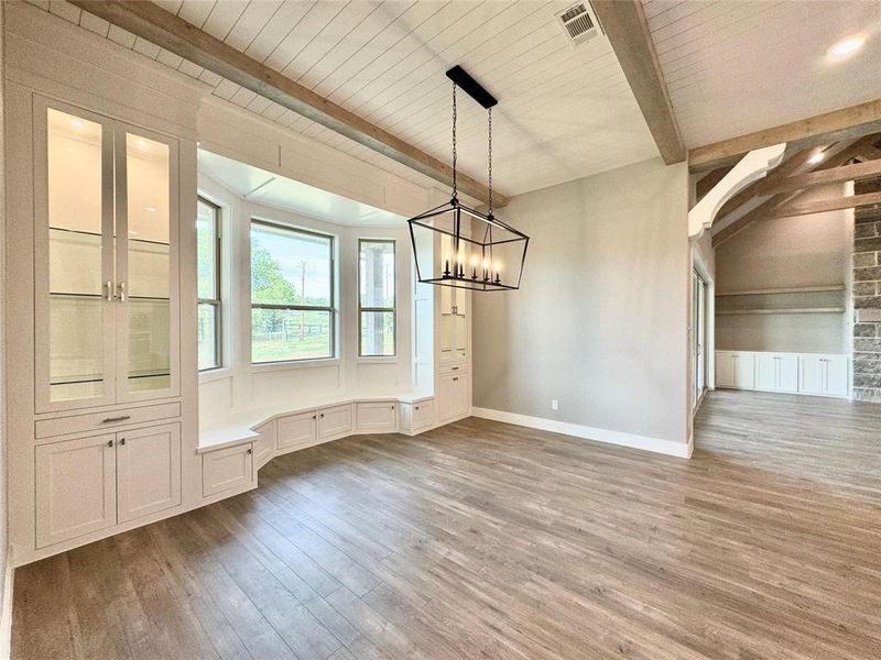 Unfurnished dining area with wood finished floors, a chandelier, baseboards, and wood ceiling