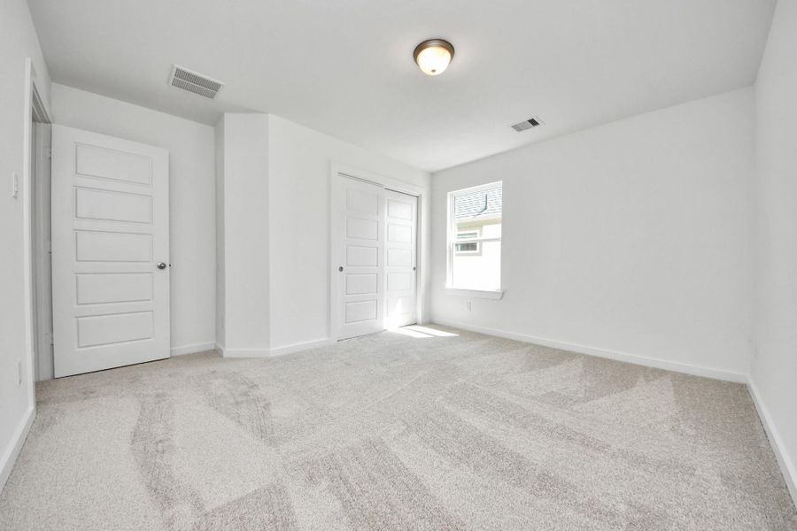 Generously sized secondary bedrooms featuring spacious closets, soft and inviting carpeting underfoot, large windows allowing plenty of natural light, and the added touch of privacy blinds for your personal retreat. Sample photo of completed home with similar floor plan. Actual colors and selections may vary.