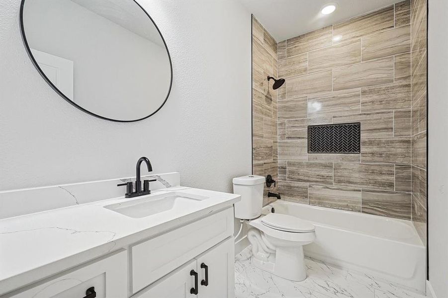 Full bathroom with vanity, toilet, and tiled shower / bath