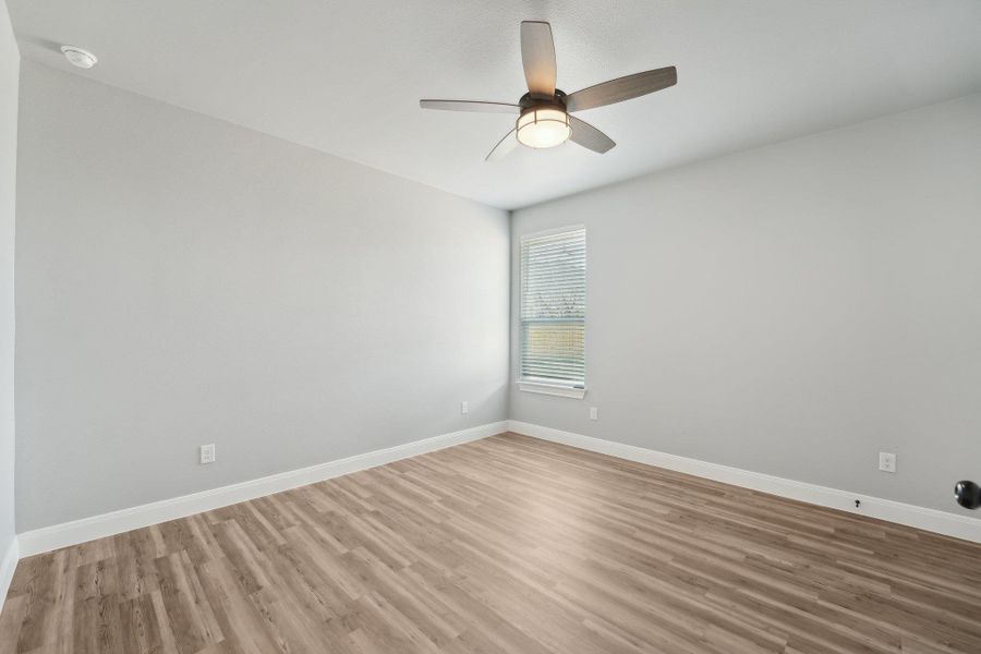 Bedroom 2 with light wood-style flooring, a ceiling fan, and baseboards