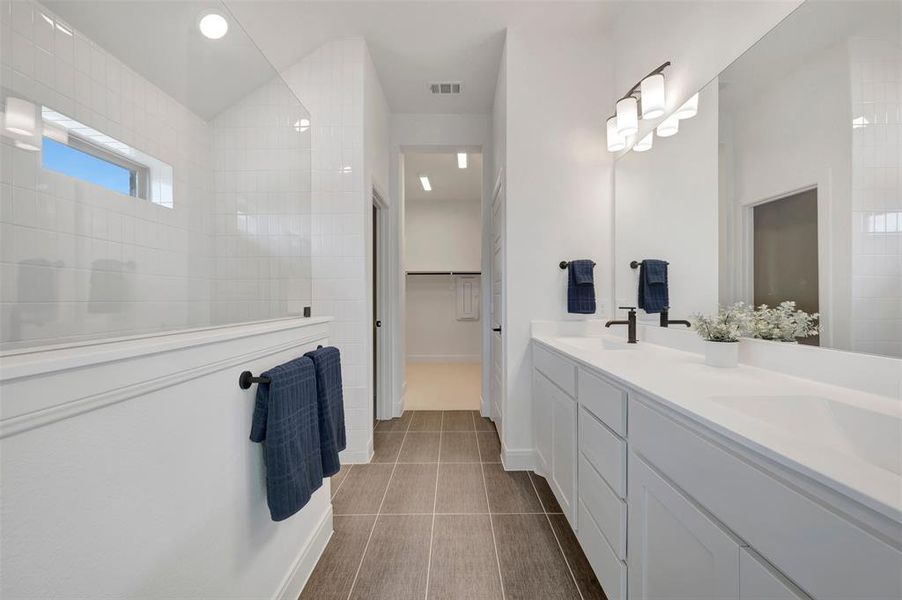 Modern bathroom featuring a dual vanity with undermount sinks, white countertops, and matte black fixtures