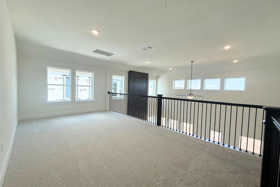A spacious upper-level loft offers an open floorplan with recessed lighting and carpeted flooring. A spacious upper-level loft offers an open floorplan with recessed lighting and carpeted flooring.