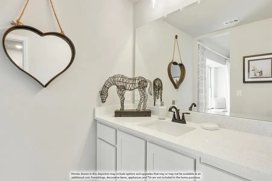 Bathroom vanity with white cabinets, quartz countertop, single sink, and heart-shaped decorative mirror on the wall. Bathroom vanity with white cabinets, quartz countertop, single sink, and heart-shaped decorative mirror on the wall.